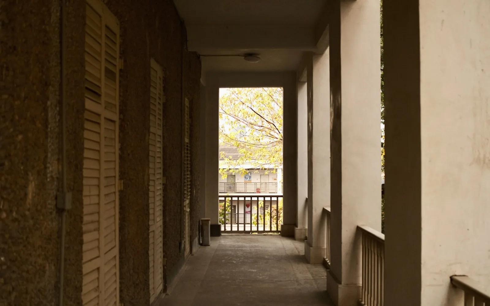 Ballatoio di un edificio residenziale con porte a persiana, affacciato sul cortile.
